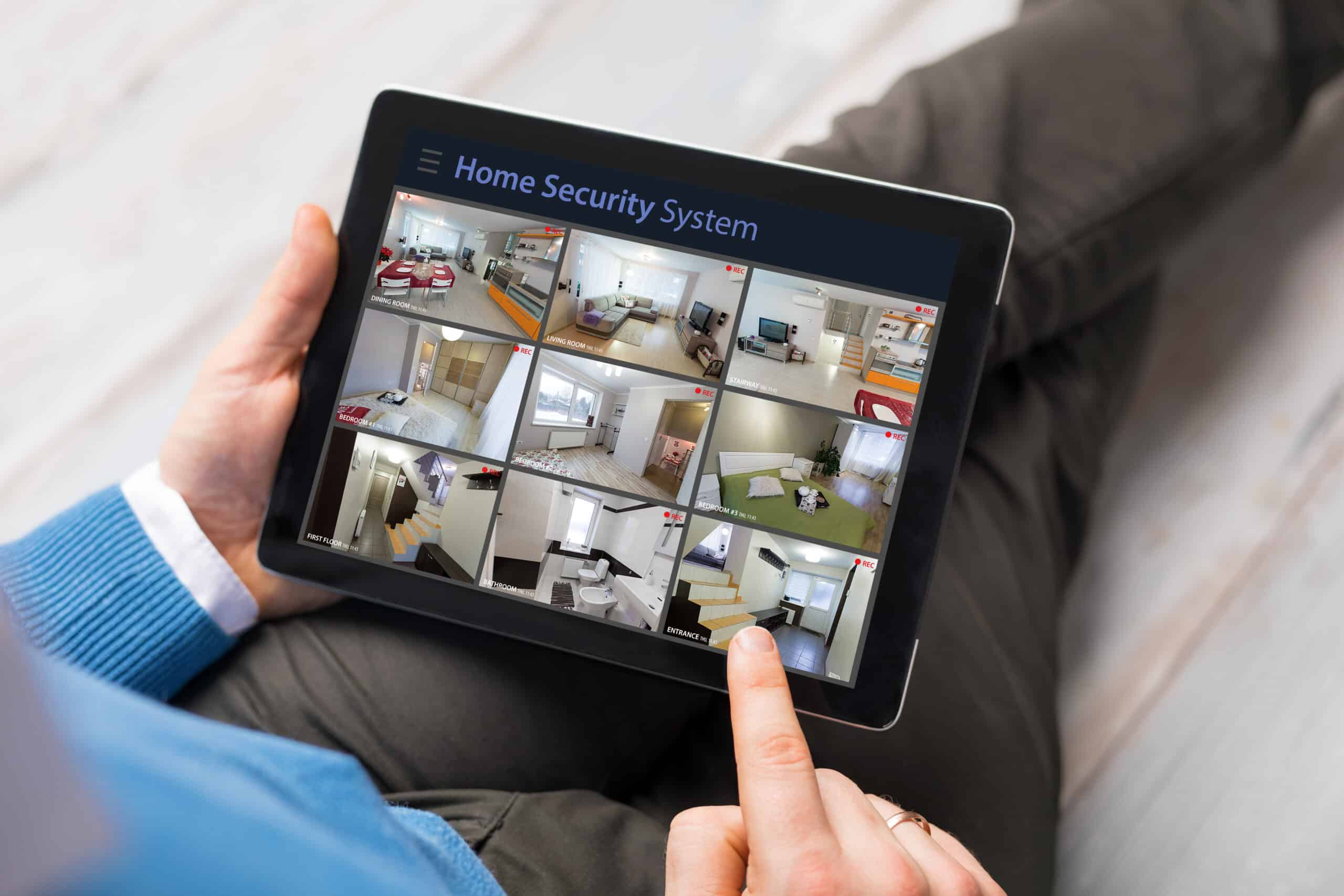 Man looking at home security cameras on tablet computer Multi-Property-Protection-Solutions-Stratford-CT-scaled